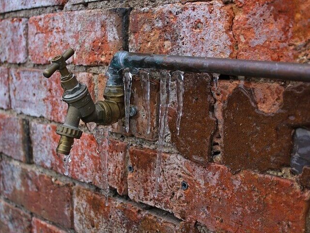 Pipe with faucet on brick wall